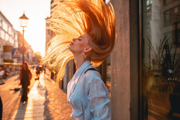 Ragazza sfoggia i suoi capelli sani in città.