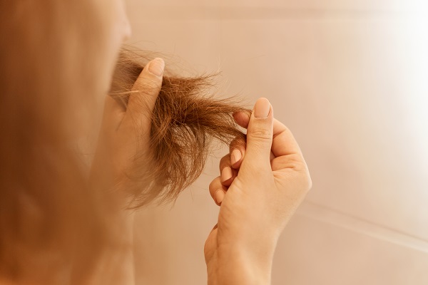Donna con capelli spenti e fragili.